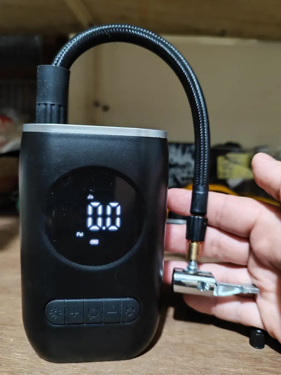 Compressor com visor ligado e conexão da mangueira mostrada na mão