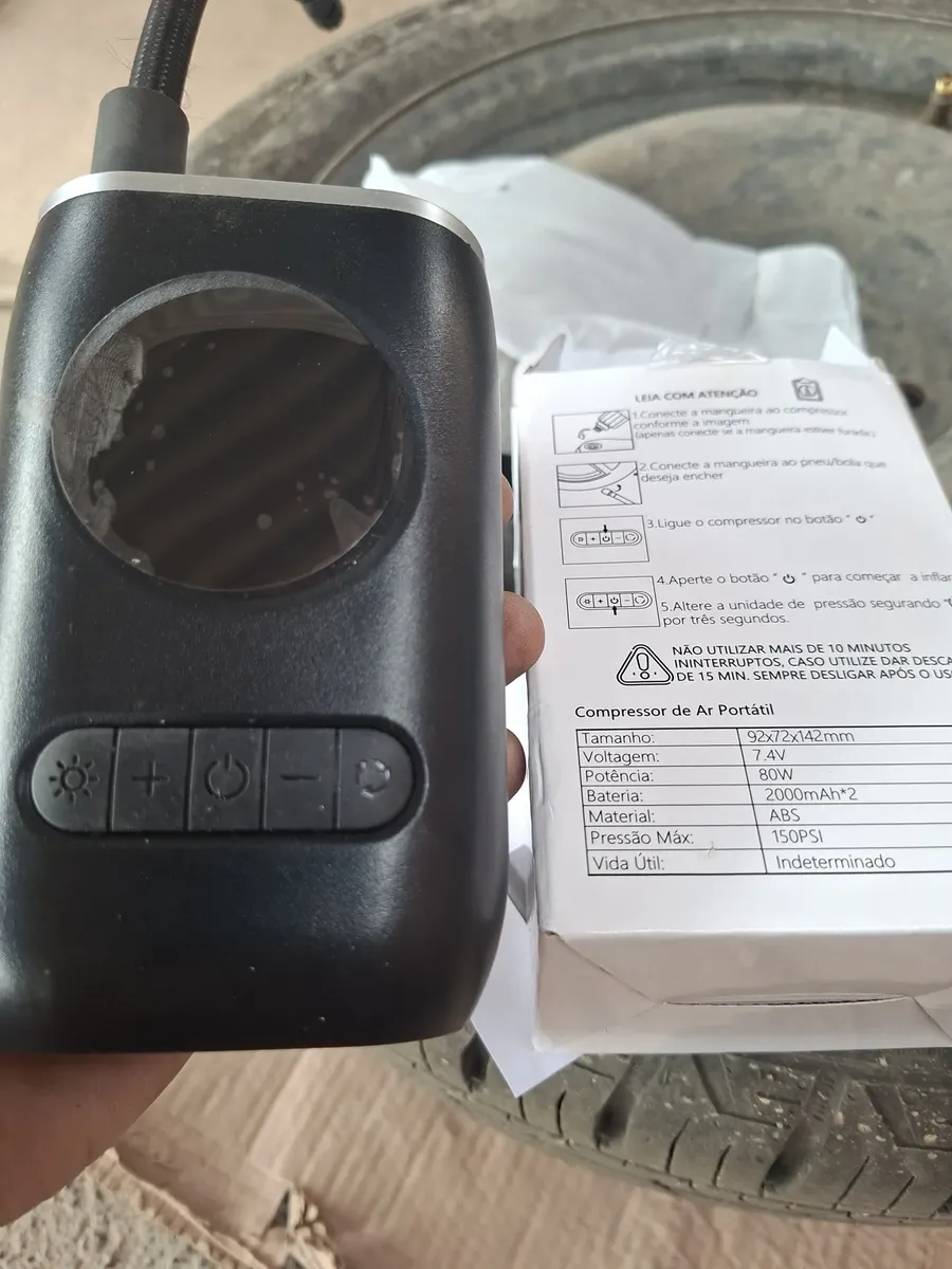 Compressor segurado na mão ao lado das instruções da embalagem